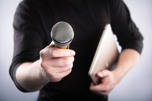 Person holding a tablet and microphone