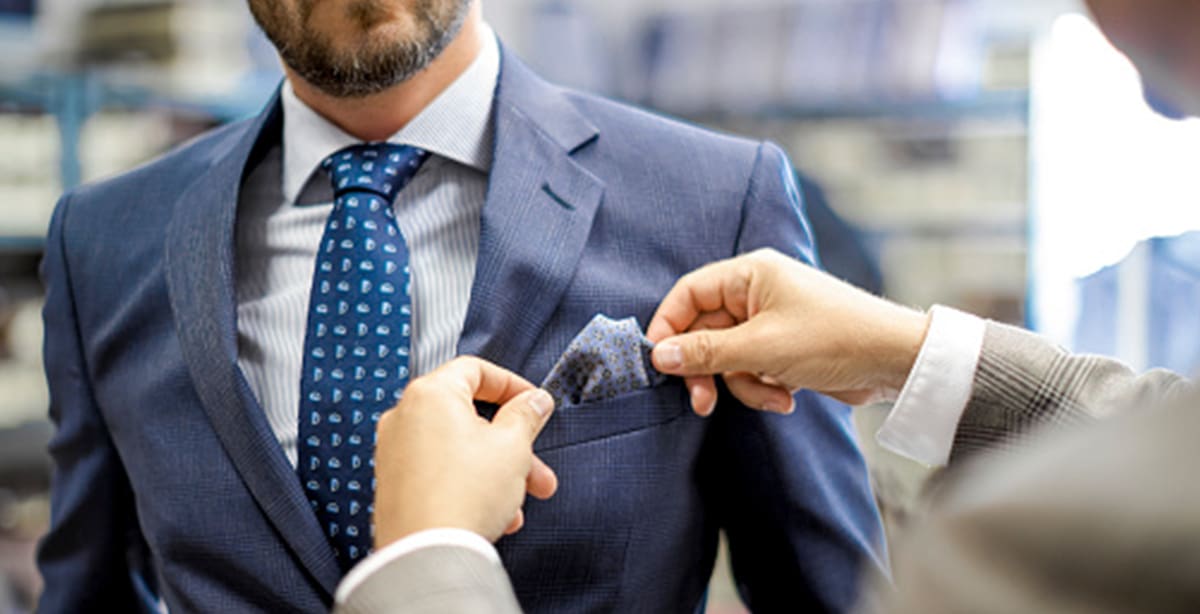 Man fixing other man's pocket square