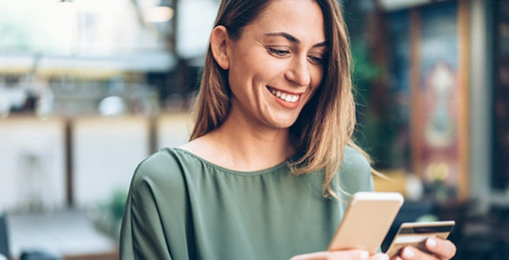 Woman smiling, checking credit card