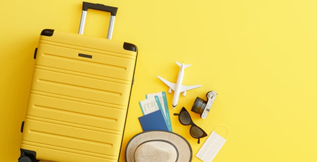 Yellow suitcase with tickets and travel accessories