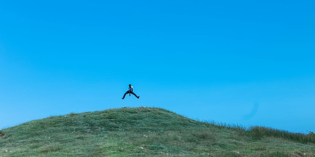 Person jumping on a hill