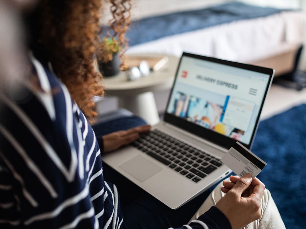 Woman on laptop holding credit card