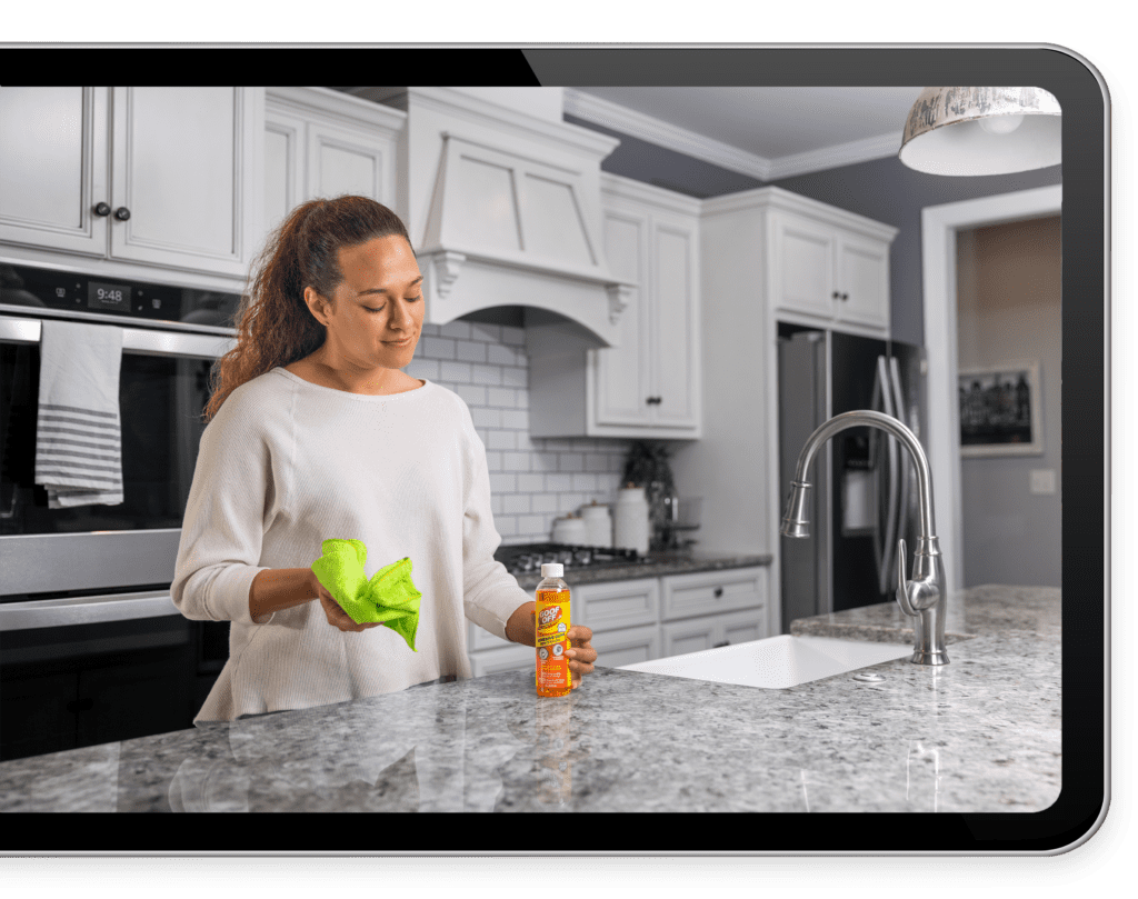 Woman using Goof Off on kitchen counter