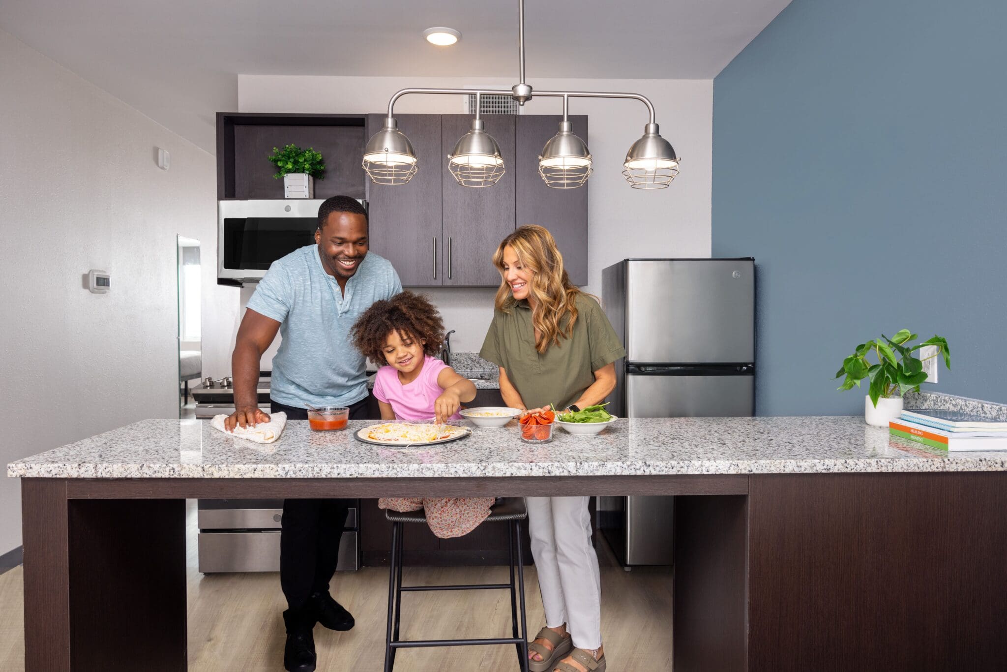 Family in the kitchen at extended stay hotel chain, stayAPT Suites